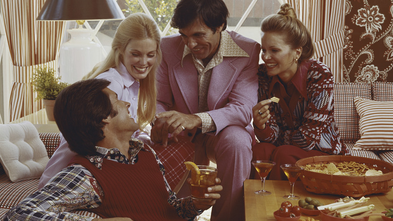Adults partying with snacks in the 1970s