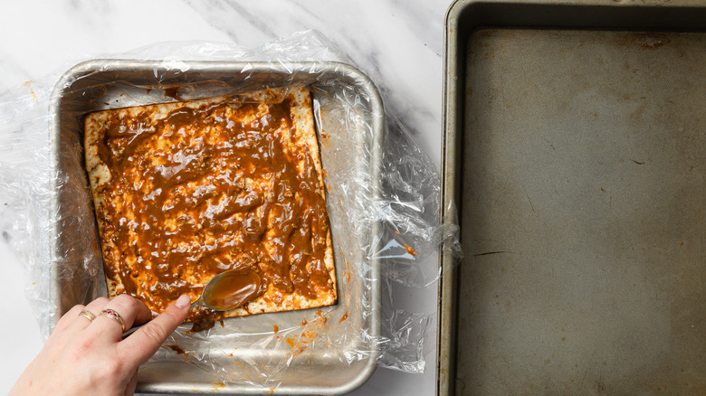 Coating matzos with dulce de leche