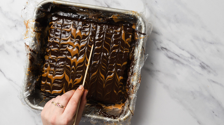 Tracing a pattern in dulce de leche and chocolate over cake