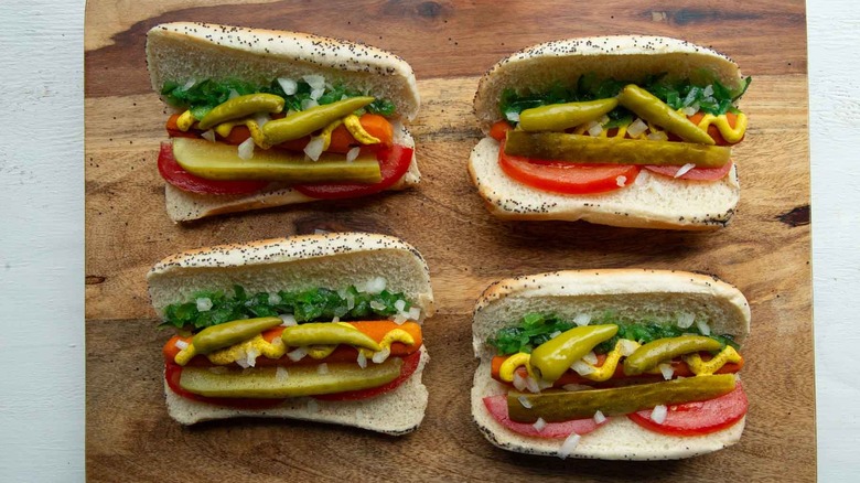 cooked carrots with condiments and garnishes in hot dog buns