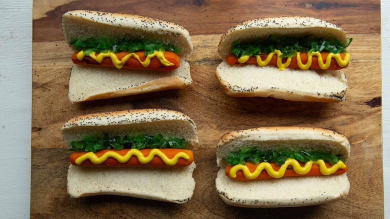 cooked carrots with condiments in hot dog buns