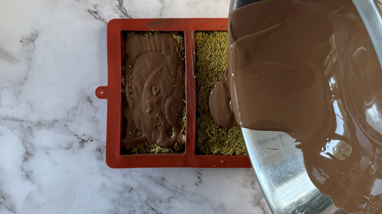 Melted chocolate pouring onto kataifi filling in chocolate bar molds