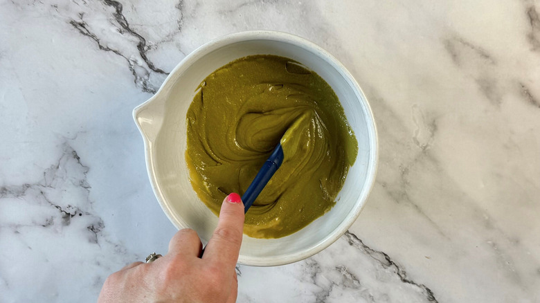 Hand stirring pistachio cream in bowl