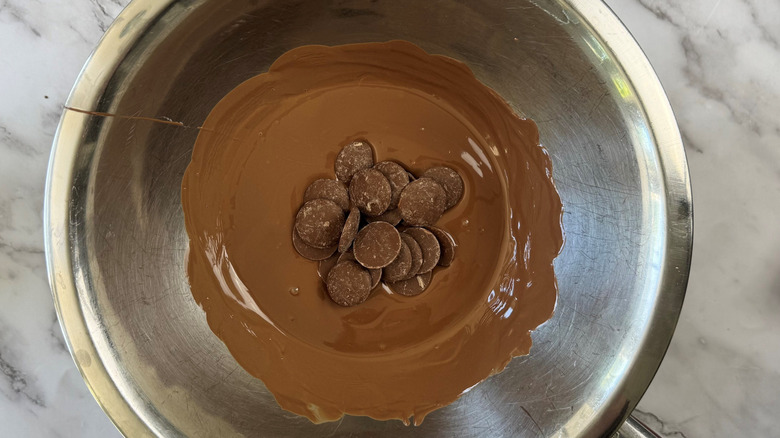 Melted chocolate and chocolate melting wafers in bowl