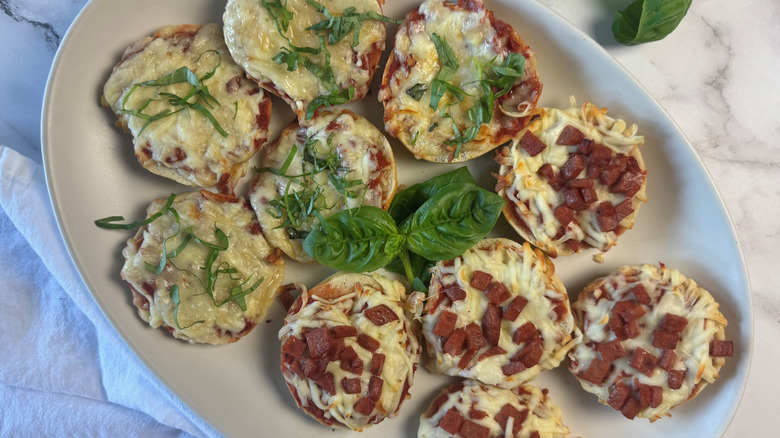 pizza bagel bites on serving platter with basil decoration