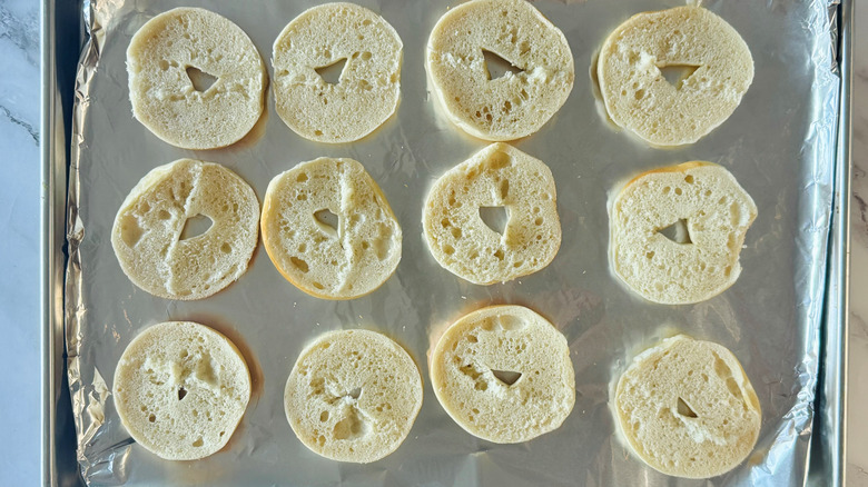 sliced bagel halves on lined baking sheet