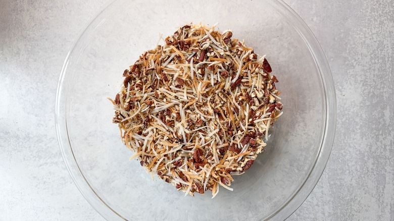 Toasted shredded coconut and chopped pecans in glass bowl