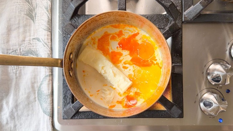 Butter, evaporated milk, sugar, and egg yolks in sauce pan on stovetop