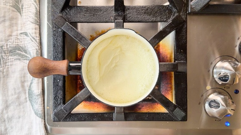 Butter and cream boiling in small saucepan on stovetop