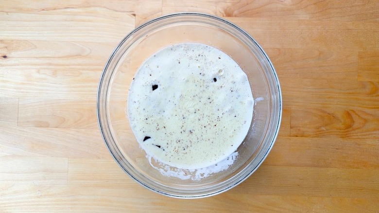 Hot cream and chopped chocolate in glass bowl on countertop