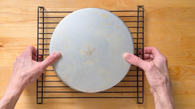 Removing cake layer from round cake pan on rack