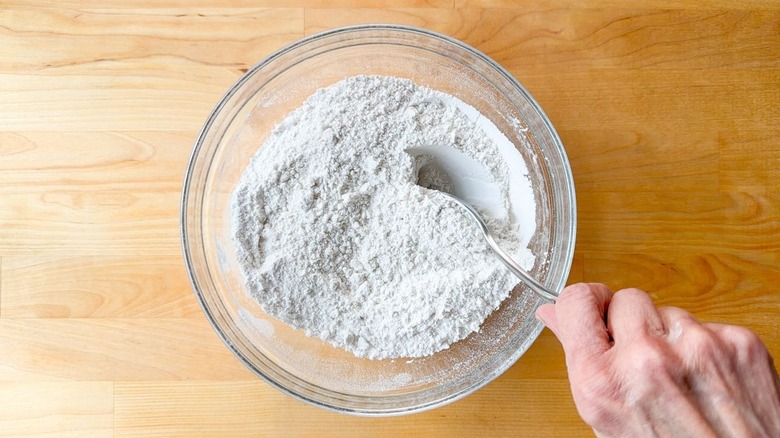 Mixing dry ingredients for cake in a glass bowl