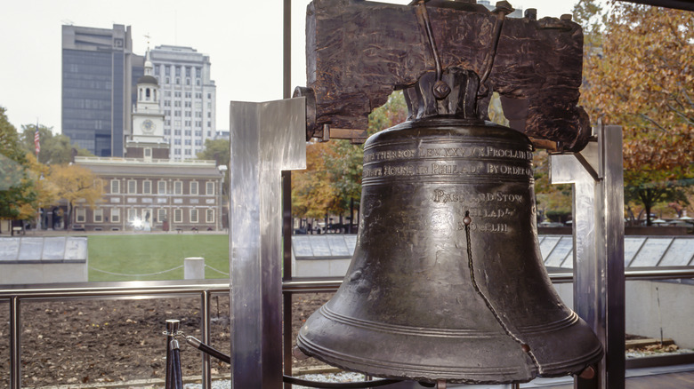 Liberty Bell with Independence Hall in background.