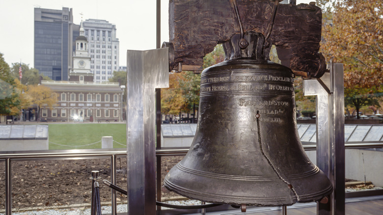 Liberty Bell with Independence Hall in background.