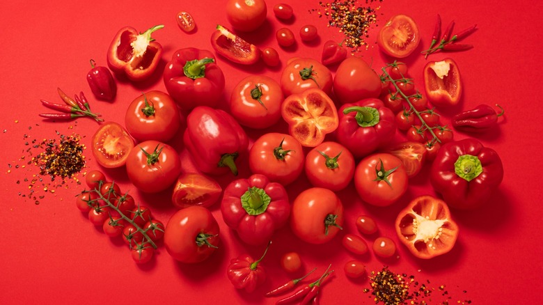 red peppers and tomatoes with red background