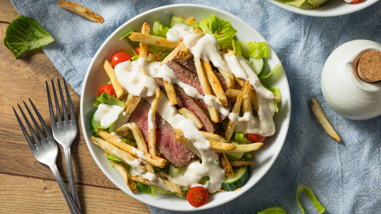 Pittsburgh salad on tablecloth with french fries on table