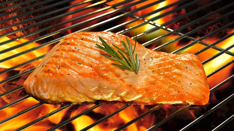 grilling salmon over flaming coals