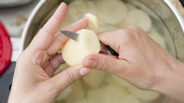 Chopped and peeled potatoes put into a pot of water