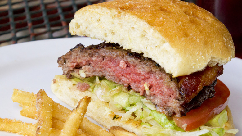 rare burger cut in half with fries