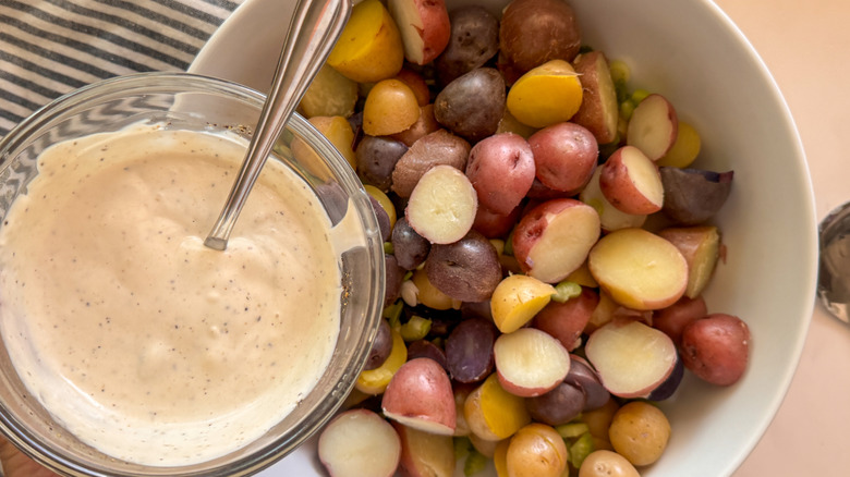 adding dressing to potato salad