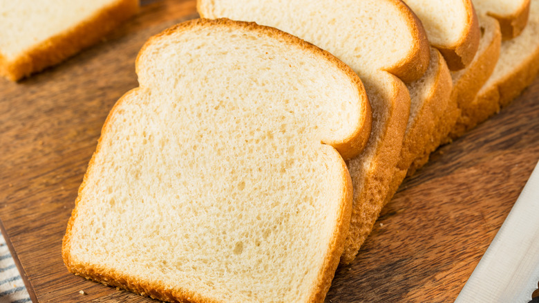 Sliced white bread on a wooden board