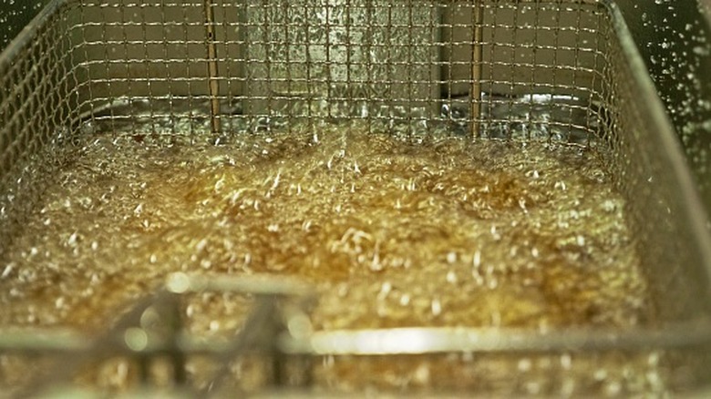 A close up of a bubbling fryer filled with partially hydrogenated oil