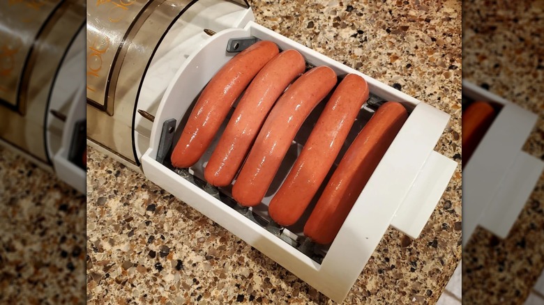 Sausages cooking on a hot dogger