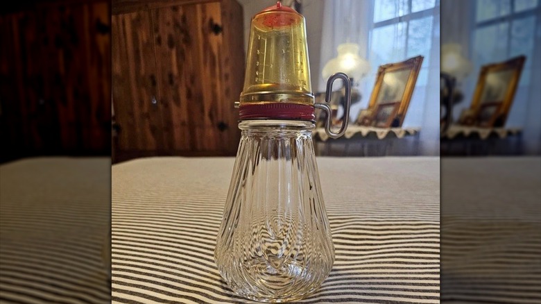 A glass turn key nut chopper