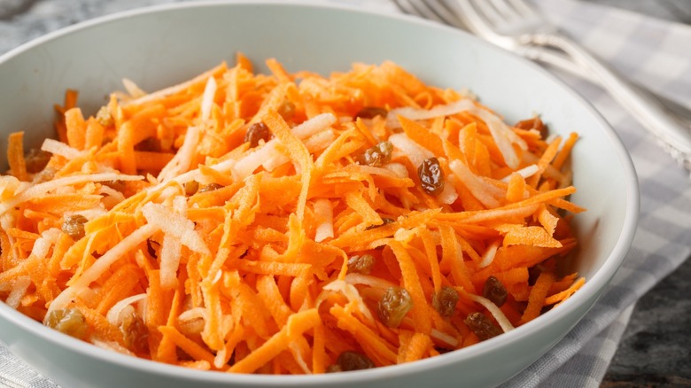 vegan carrot and raisin salad in a white bowl