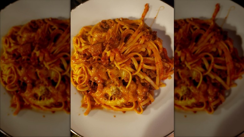 creole spaghetti with melted cheese on white plate
