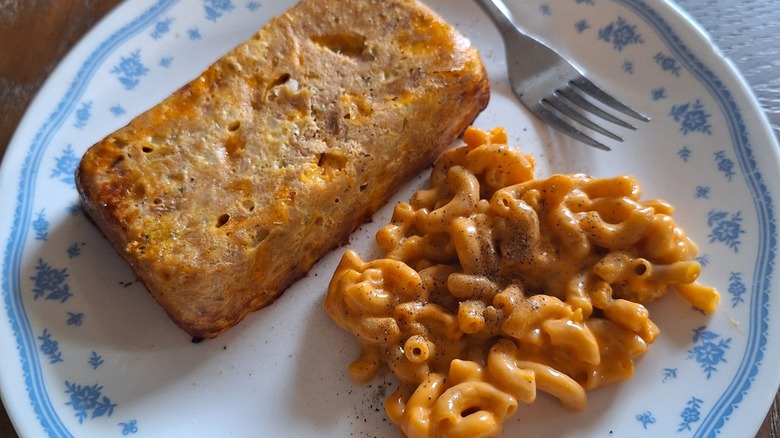 tuna loaf served alongside pasta and sauce on white plate