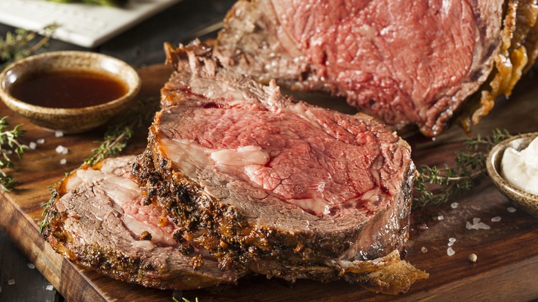 Prime rib with piece cut off on wood board