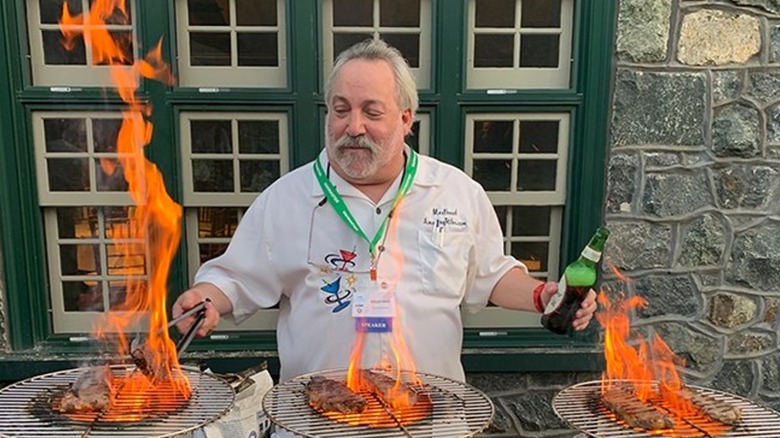 Meathead cooking meat over flames