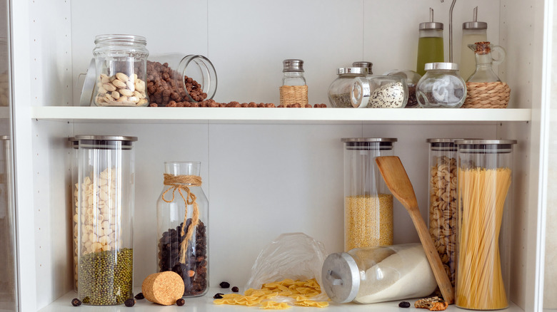 Closeup of cluttered kitchen shelf with spilled food items.
