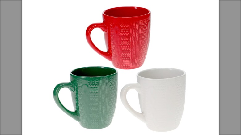 A set of three coffee mugs, one red, one green, and one white
