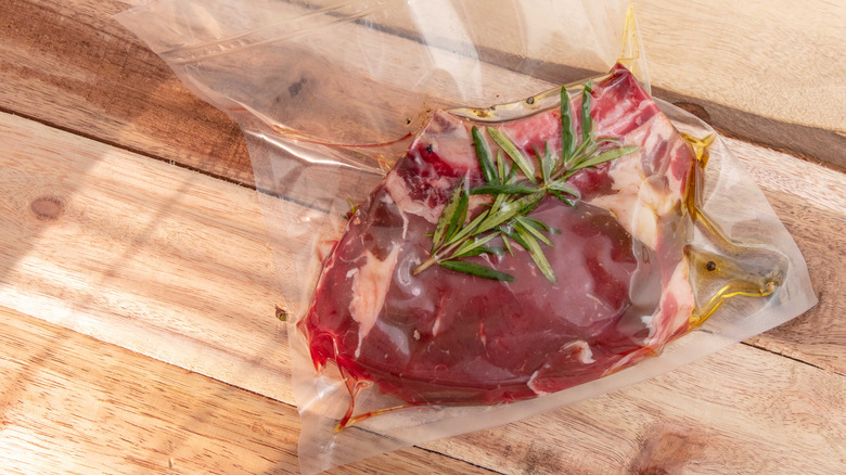 Steak sealed in a sous vide bag on a wooden surface