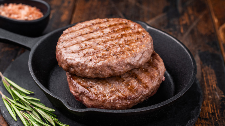 Two meat patties in a cast iron skillet