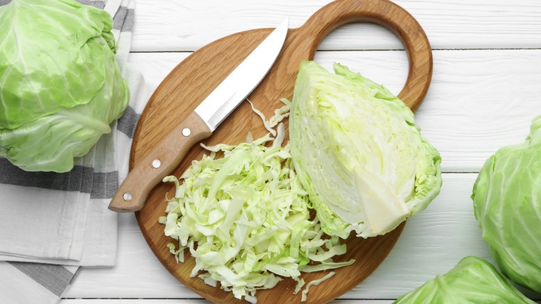 sliced cabbage with knife on cutting board