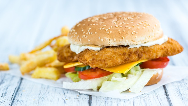 fried fish sandwich with veggies and fries