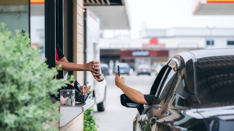 passenger pays for food at drive-thru