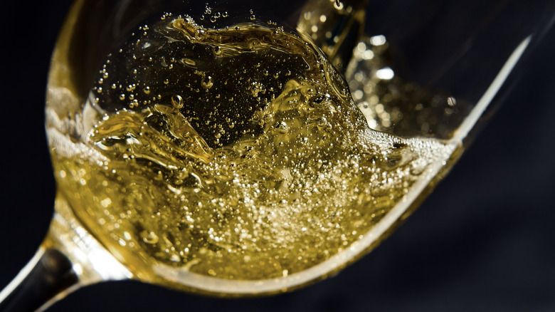 Close-up of white wine being poured into a glass