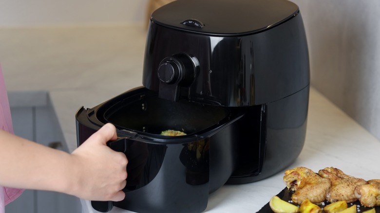 hand pushing drawer in air fryer