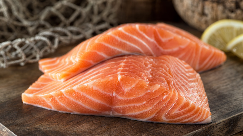 Fresh raw salmon fillets on a wooden board