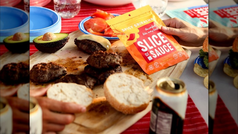 Burgers at a cookout along with Slice Of Sauce packets