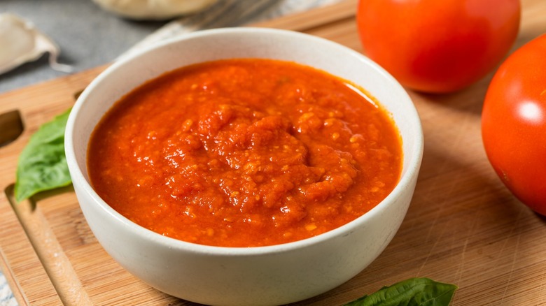 marinara sauce on board with tomatoes and basil