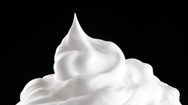 White whipped cream against a black background.