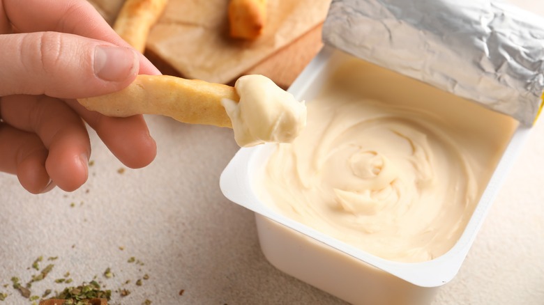 dipping bread stick in cream cheese