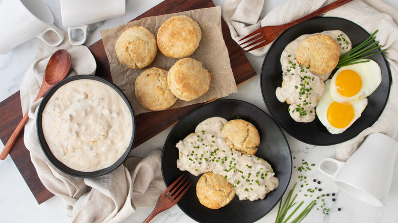 Overhead shot of biscuits and gravy with additional biscuits and gravy on the side.