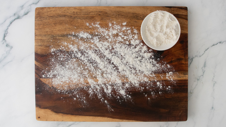 A wood cutting board sprinkled with flour