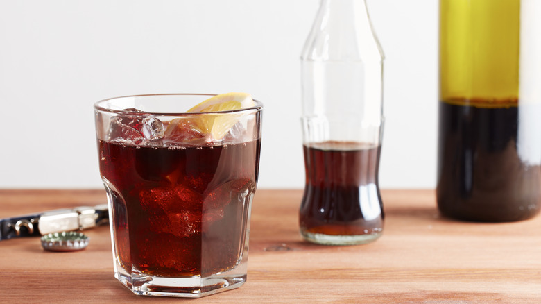 Kalimotxo with half empty Coke and red wine bottles